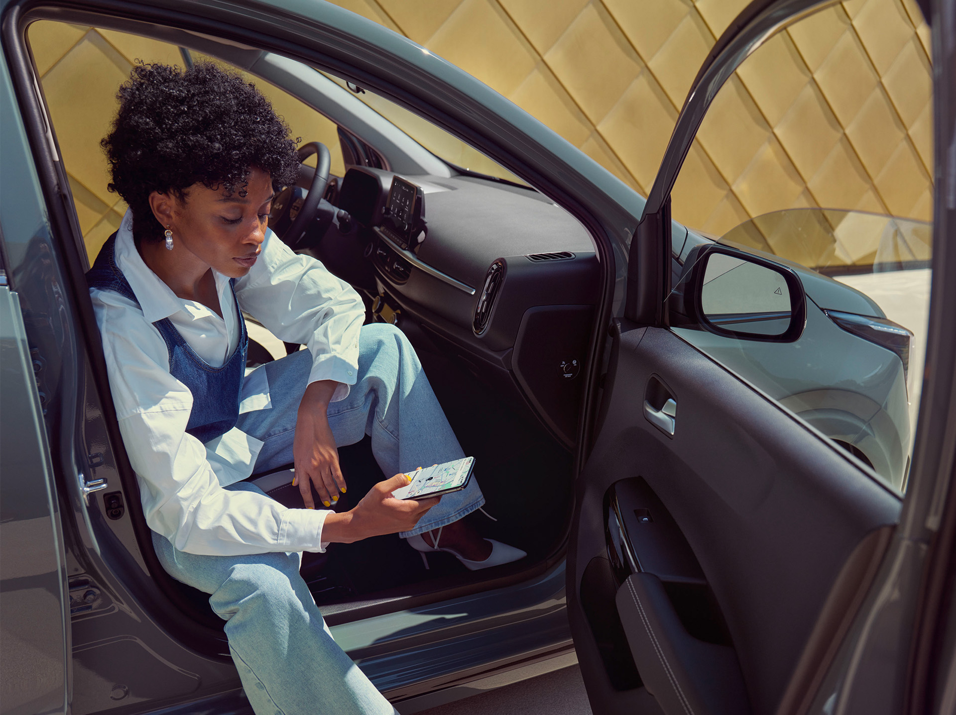 Frau mit Handy im Kia Picanto
